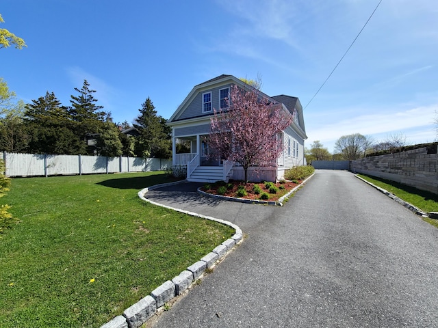 23 Old Barnstable Rd, East Falmouth, MA 02536 - view of front of home with fence, covered porch, a gambrel roof, and a front yard