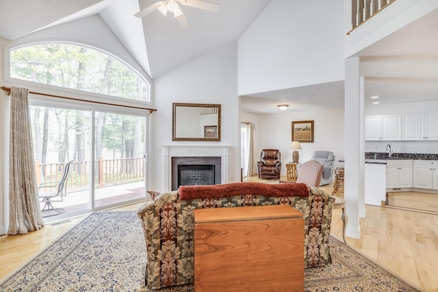 13 Laurel Hill Ct, Bourne, MA 02532 - living area featuring high vaulted ceiling, light wood finished floors, a fireplace, and a ceiling fan