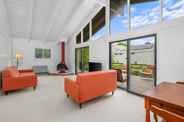 128 Whippoorwill Cir, Mashpee, MA 02649 - carpeted living area with a wood stove, beam ceiling, and high vaulted ceiling