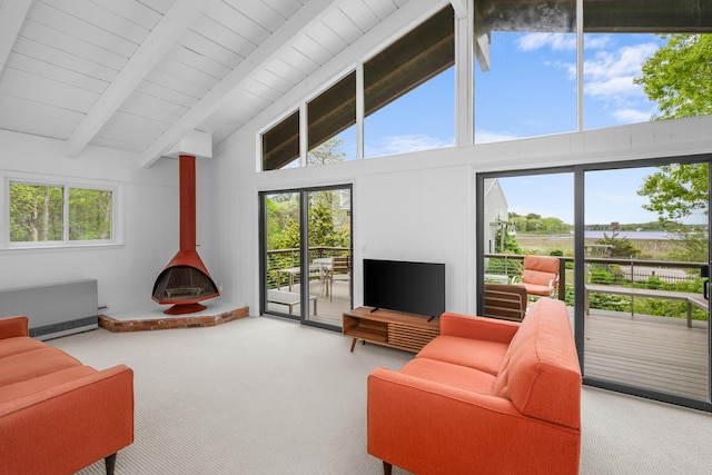 128 Whippoorwill Cir, Mashpee, MA 02649 - living room featuring carpet floors, a wood stove, beam ceiling, radiator heating unit, and high vaulted ceiling
