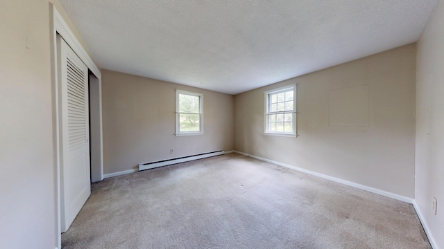 10 Freeman Rd, Yarmouth Port, MA 02675 - unfurnished bedroom featuring a baseboard heating unit, carpet flooring, a closet, and a textured ceiling