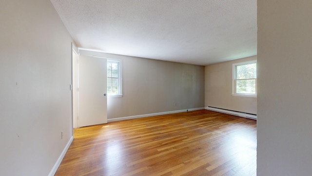 10 Freeman Rd, Yarmouth Port, MA 02675 - spare room featuring baseboard heating, plenty of natural light, light wood-style floors, and a textured ceiling