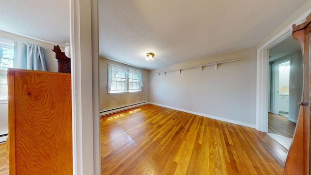 10 Freeman Rd, Yarmouth Port, MA 02675 - unfurnished room with a baseboard heating unit, wood finished floors, and a textured ceiling