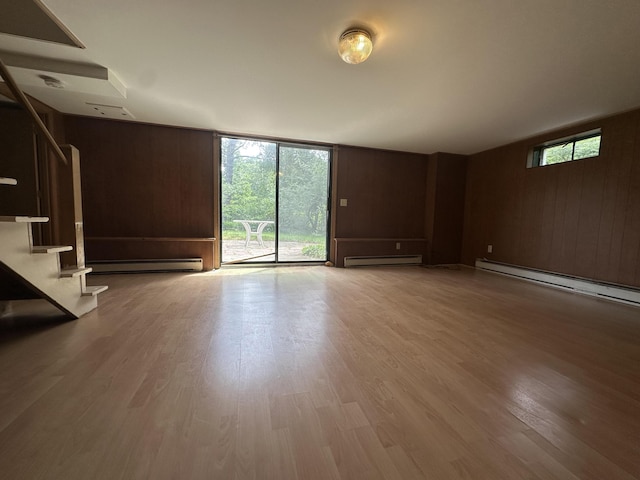 10 Freeman Rd, Yarmouth Port, MA 02675 - unfurnished living room with a baseboard radiator, a baseboard heating unit, wood finished floors, stairway, and expansive windows