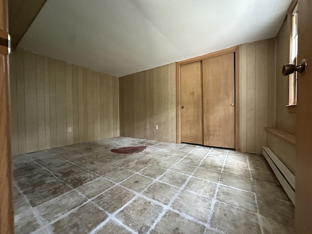 10 Freeman Rd, Yarmouth Port, MA 02675 - unfurnished bedroom featuring a baseboard heating unit, wooden walls, and a closet