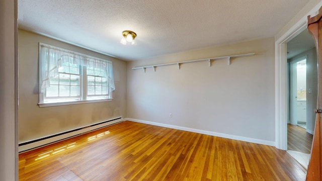 10 Freeman Rd, Yarmouth Port, MA 02675 - spare room featuring a baseboard heating unit, light wood finished floors, and a textured ceiling
