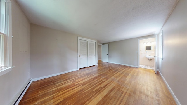 10 Freeman Rd, Yarmouth Port, MA 02675 - unfurnished bedroom featuring a baseboard heating unit, light wood finished floors, and a closet