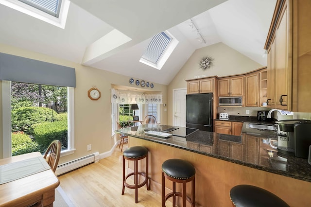 4 Square Rigger Ln, Hyannis, MA 02601 - kitchen featuring black appliances, a skylight, baseboard heating, a peninsula, and high vaulted ceiling