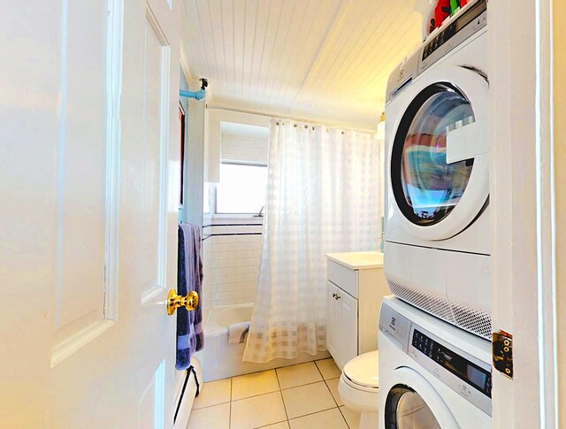 full bathroom with tile patterned flooring, stacked washing maching and dryer, toilet, vanity, and shower / bathtub combination with curtain