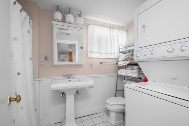 5 Highland Ln, Harwich Port, MA 02646 - bathroom with stacked washer / dryer, wainscoting, and tile patterned flooring