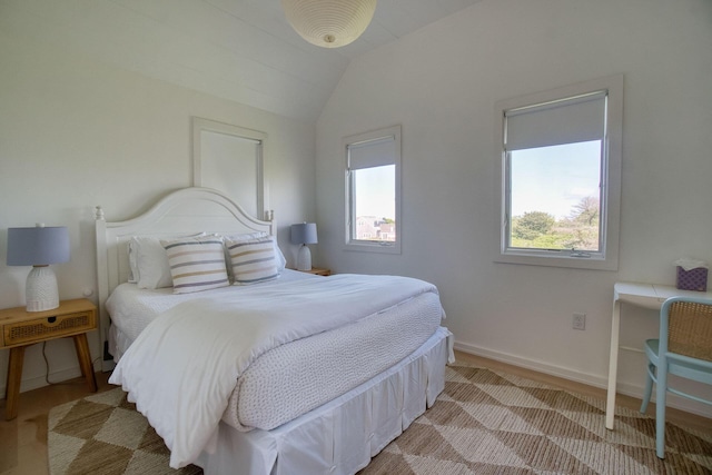 bedroom with light hardwood / wood-style floors and lofted ceiling