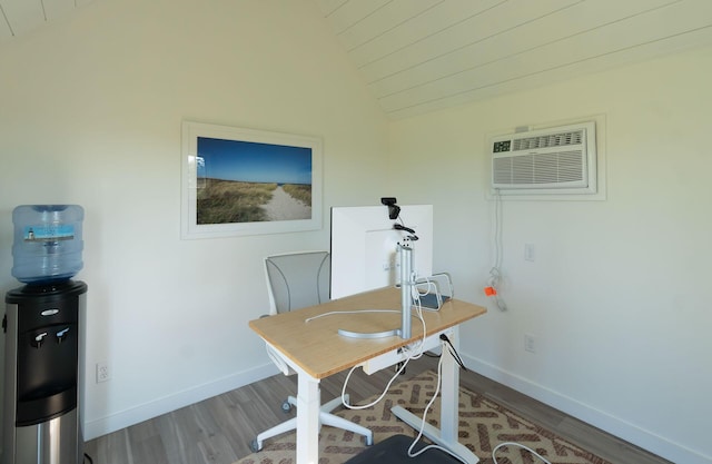 home office featuring a wall mounted air conditioner, vaulted ceiling, and hardwood / wood-style flooring