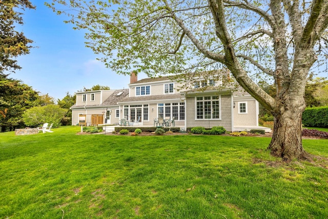 46 Freeman Ln, Orleans, MA 02653 - back of property featuring a chimney, a lawn, and a patio area
