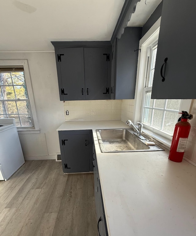 kitchen featuring light countertops, light wood-style flooring, range, and a sink