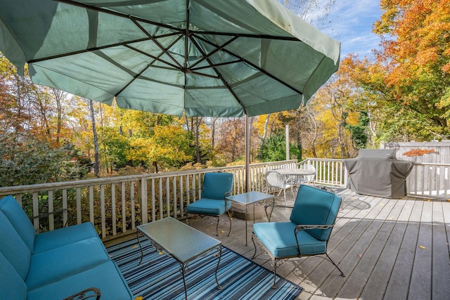 wooden terrace with an outdoor living space and area for grilling