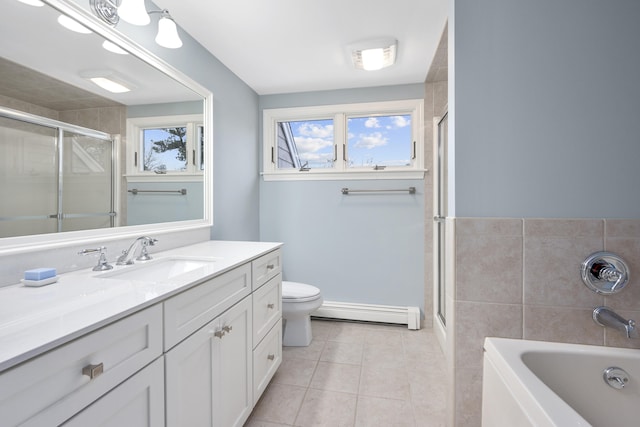 full bathroom with tile patterned floors, toilet, tile walls, baseboard heating, and vanity