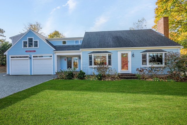 view of front of home with an attached garage, gravel driveway, a front yard, and a shingled roof