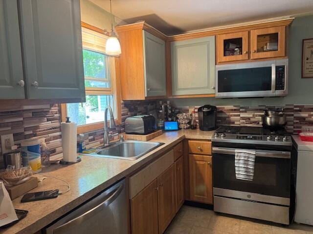 155 Mitchells Way, Barnstable, MA 02601 - kitchen with stainless steel appliances, decorative backsplash, pendant lighting, light countertops, and glass insert cabinets