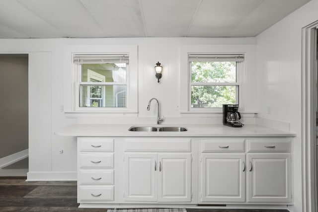 kitchen with sink, white cabinets, and dark wood-type flooring