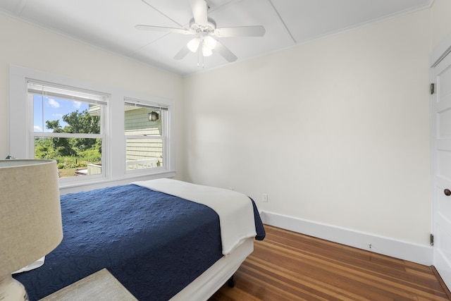 bedroom with dark hardwood / wood-style floors and ceiling fan