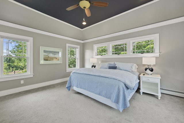 carpeted bedroom with multiple windows, a baseboard heating unit, ceiling fan, and ornamental molding