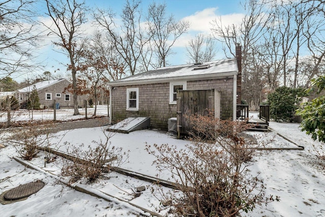 view of snow covered back of property