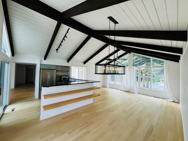 kitchen with sink, lofted ceiling with beams, green cabinetry, light hardwood / wood-style floors, and stainless steel appliances