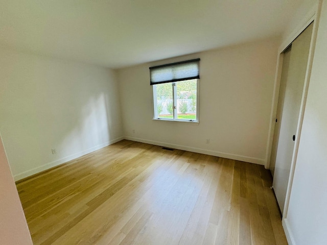 unfurnished bedroom featuring light hardwood / wood-style flooring and a closet