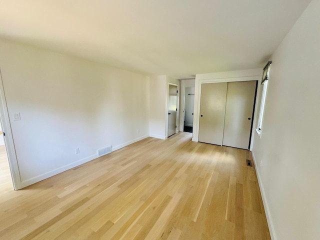 unfurnished bedroom featuring a closet and light wood-type flooring