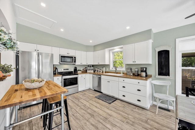 39 Nehoiden Rd, Mashpee, MA 02649 - kitchen featuring appliances with stainless steel finishes, a sink, healthy amount of natural light, wood counters, and vaulted ceiling