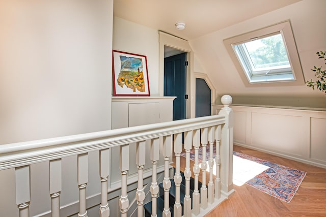 3 Carver Ct, Provincetown, MA 02657 - corridor featuring a skylight, a decorative wall, a wainscoted wall, an upstairs landing, and light wood-style flooring