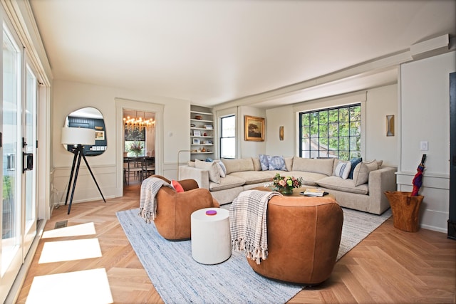 3 Carver Ct, Provincetown, MA 02657 - living area with a chandelier, a decorative wall, built in shelves, and a wainscoted wall