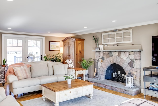 living area featuring recessed lighting, a fireplace, wood finished floors, and crown molding