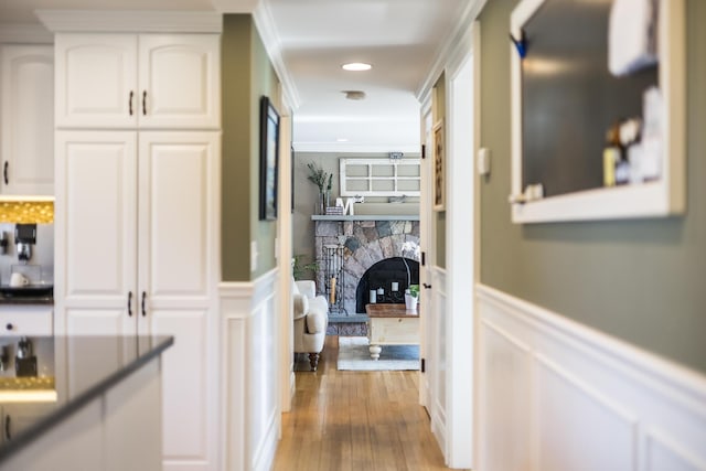 corridor with recessed lighting, wainscoting, light wood-style floors, and ornamental molding