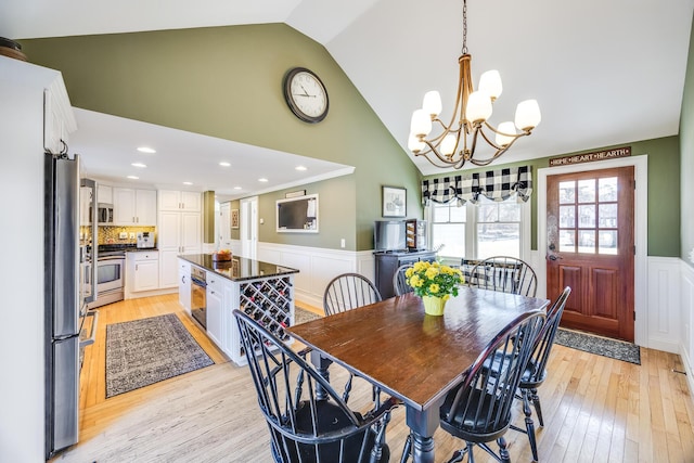 dining area with crown molding, a wainscoted wall, light wood-type flooring, recessed lighting, and a notable chandelier