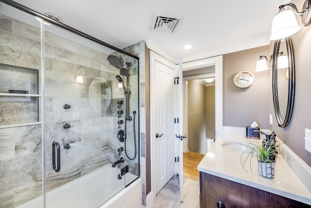 full bathroom featuring combined bath / shower with glass door, visible vents, ornamental molding, and vanity