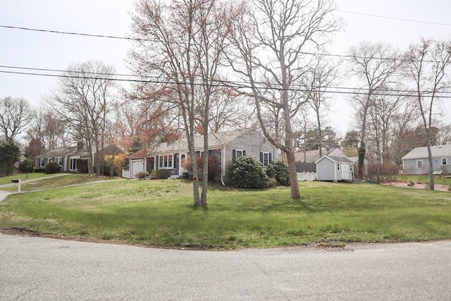 ranch-style house with a residential view, a front lawn, and an attached garage