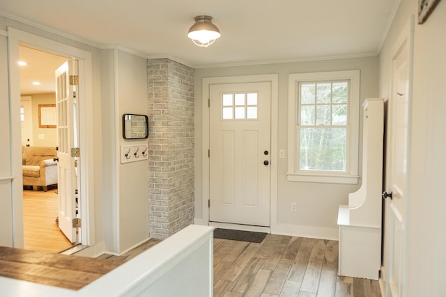 entrance foyer with baseboards, light wood-style floors, and crown molding