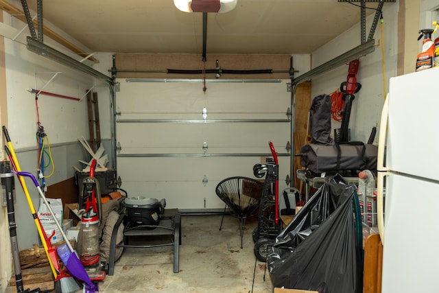 garage with a garage door opener and freestanding refrigerator