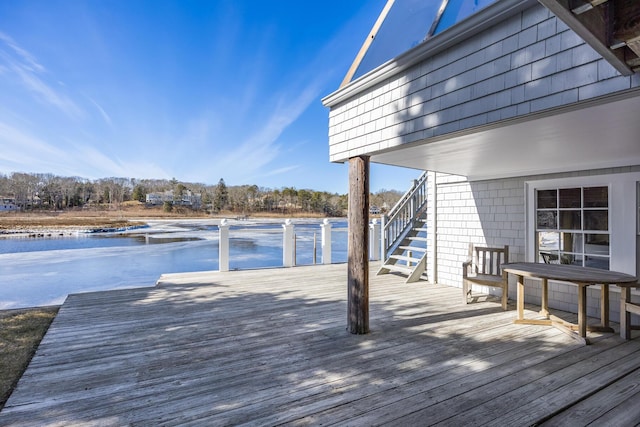 wooden terrace featuring a water view and stairway