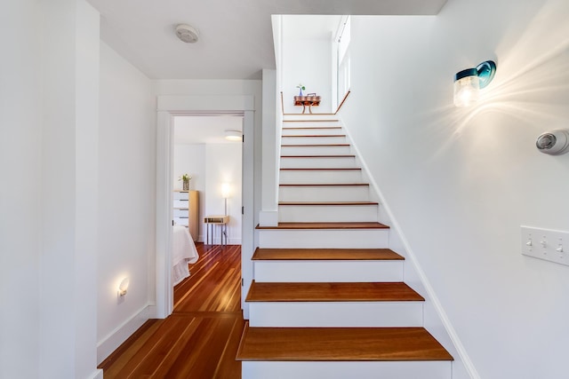 stairway featuring baseboards and wood finished floors