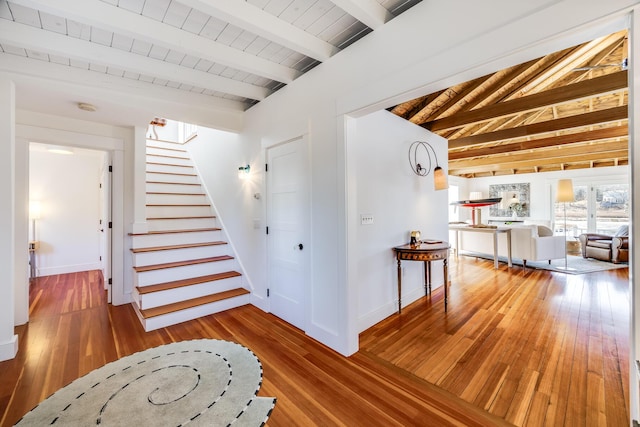 hallway featuring vaulted ceiling with beams, wood-type flooring, stairs, and wood ceiling