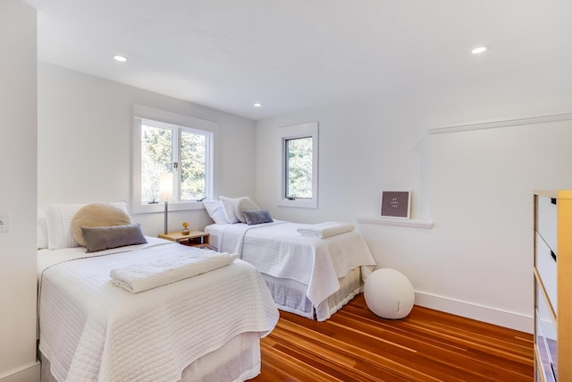 bedroom with baseboards, wood finished floors, and recessed lighting