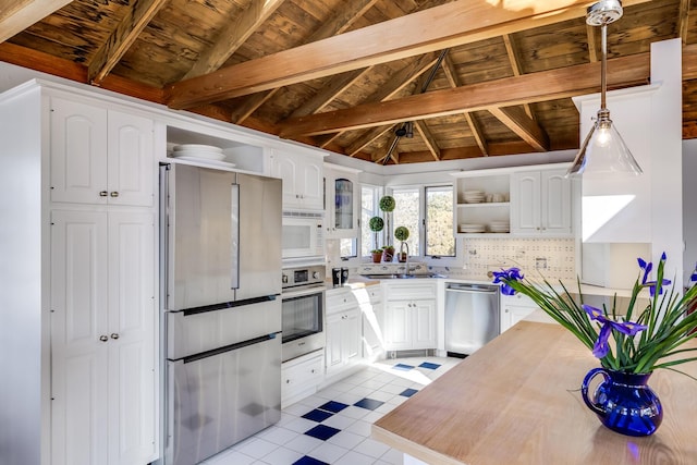 kitchen with vaulted ceiling with beams, open shelves, stainless steel appliances, light countertops, and white cabinetry