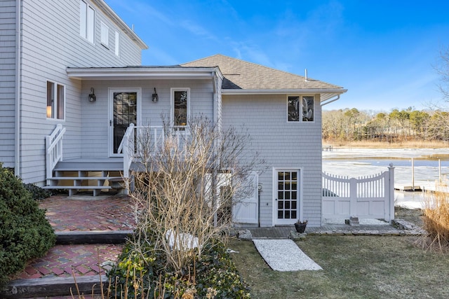 rear view of property featuring roof with shingles and a patio