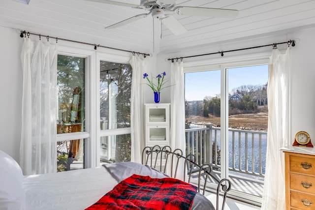 sunroom / solarium with ceiling fan and a water view