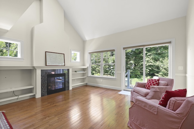 21 Pine St Unit 1Au, North Falmouth, MA 02556 - living room featuring hardwood / wood-style floors, a tile fireplace, plenty of natural light, high vaulted ceiling, and built in shelves