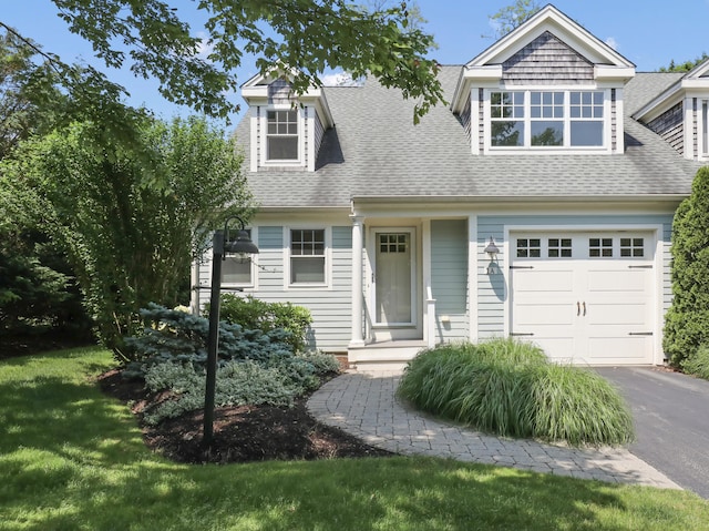 21 Pine St Unit 1Au, North Falmouth, MA 02556 - view of front of home featuring a shingled roof, a garage, asphalt driveway, and a front lawn