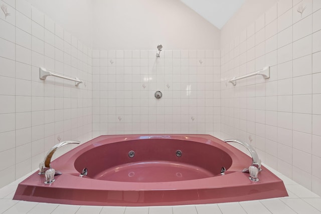 bathroom featuring tiled bath, tile walls, and vaulted ceiling