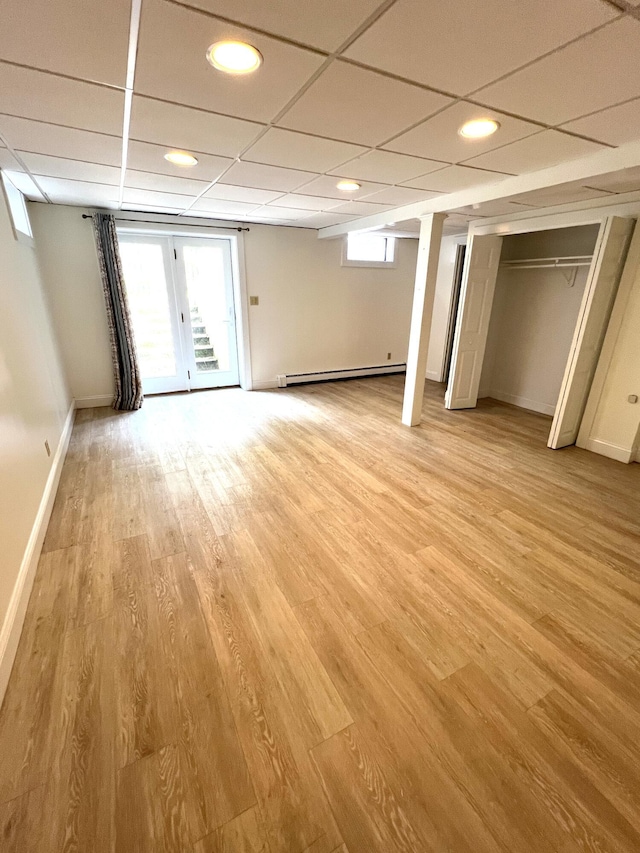 27 Long View Dr, Orleans, MA 02653 - basement with a baseboard radiator, baseboards, a paneled ceiling, light wood-style flooring, and recessed lighting